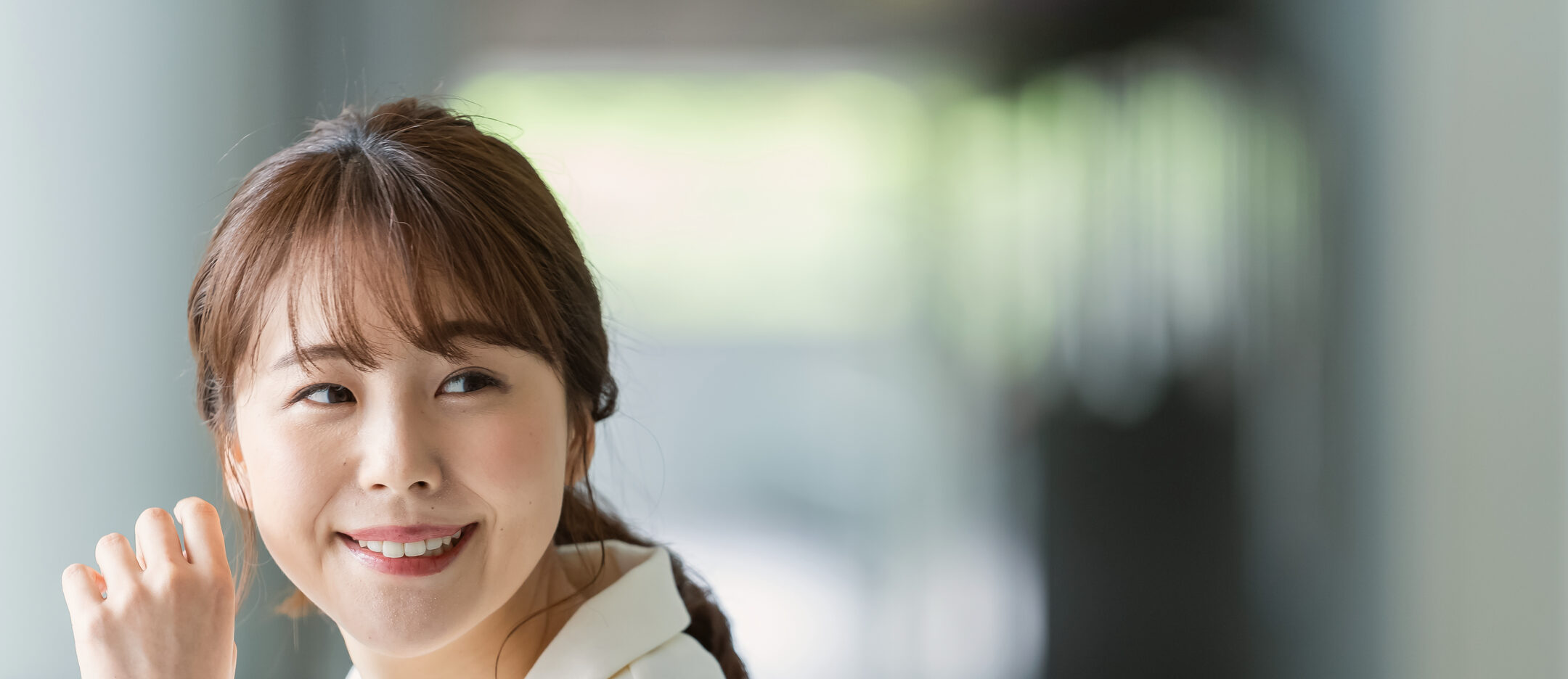 窓辺の光のなかで先を見つめる女性